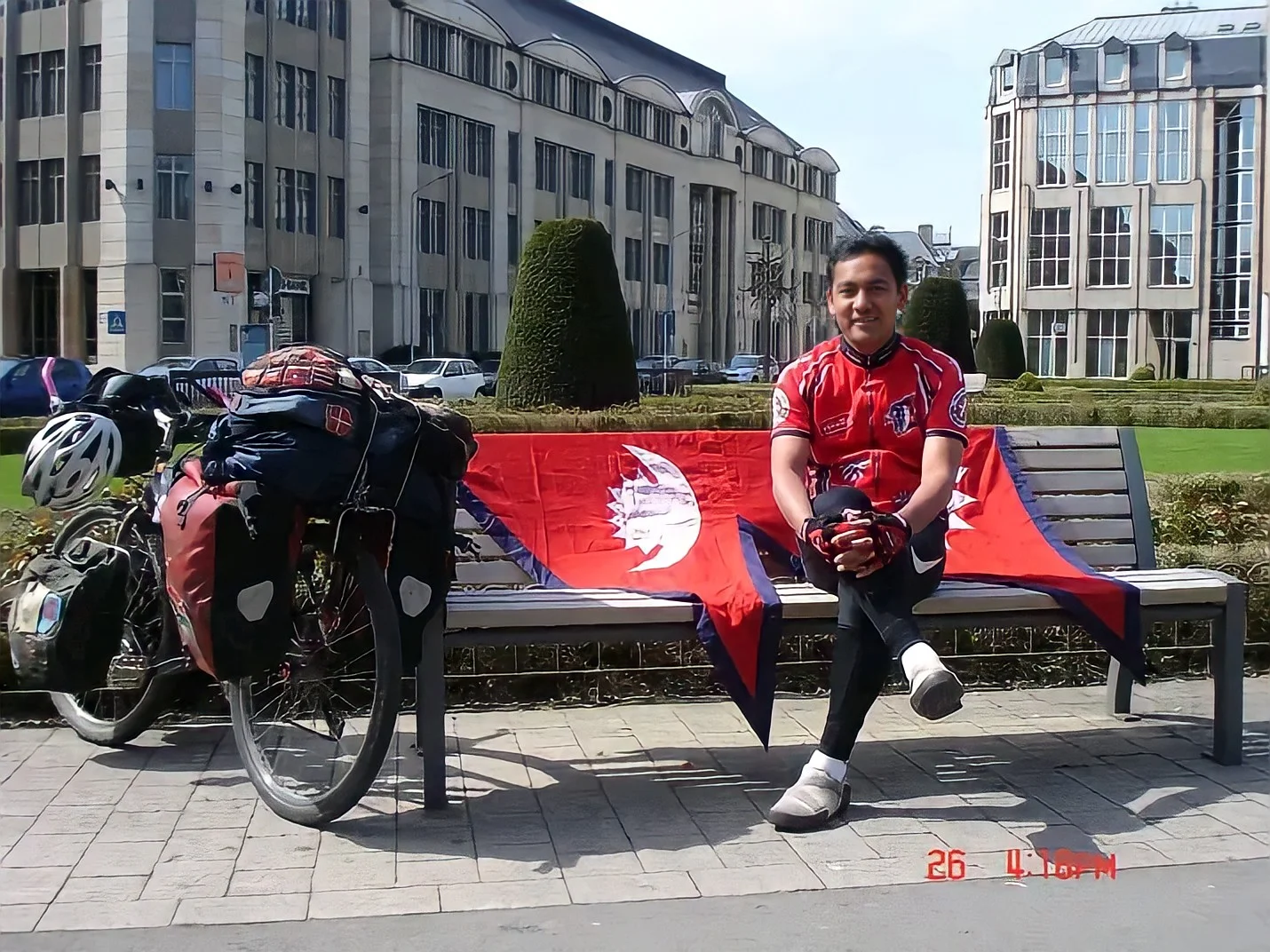 pushkar shah sitting in bench scatering nepal flag